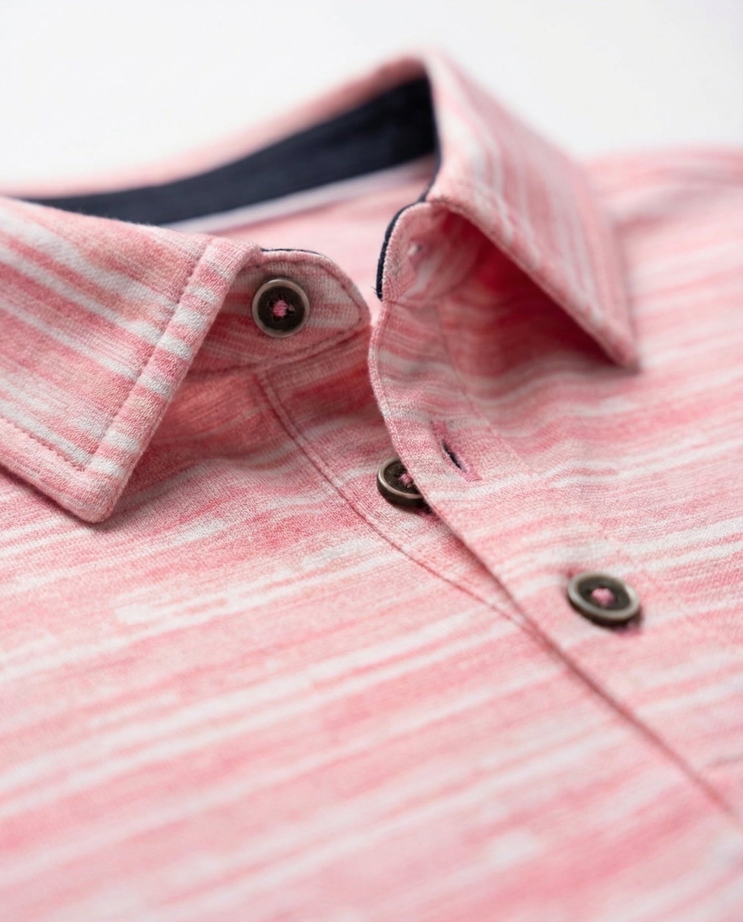 Close-up of a pink and white striped shirt with buttons.