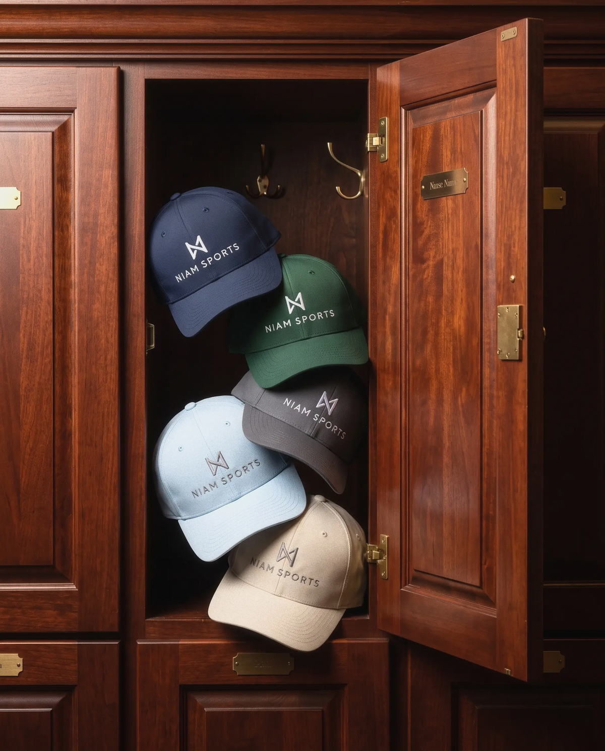 All five NIAM Sports Performance Golf Cap colorways stacked in an open mahogany club locker: Navy, Dark Green, Charcoal, Soft Blue and Stone