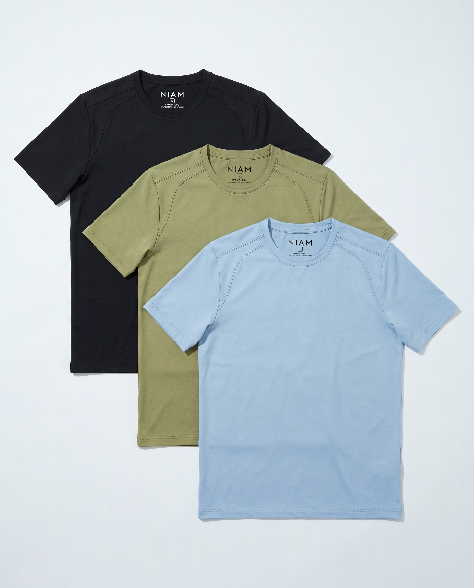 Three short-sleeve crew-neck t-shirts by NIAM in black, olive green, and light blue, arranged in a stacked fan layout on a light gray background.