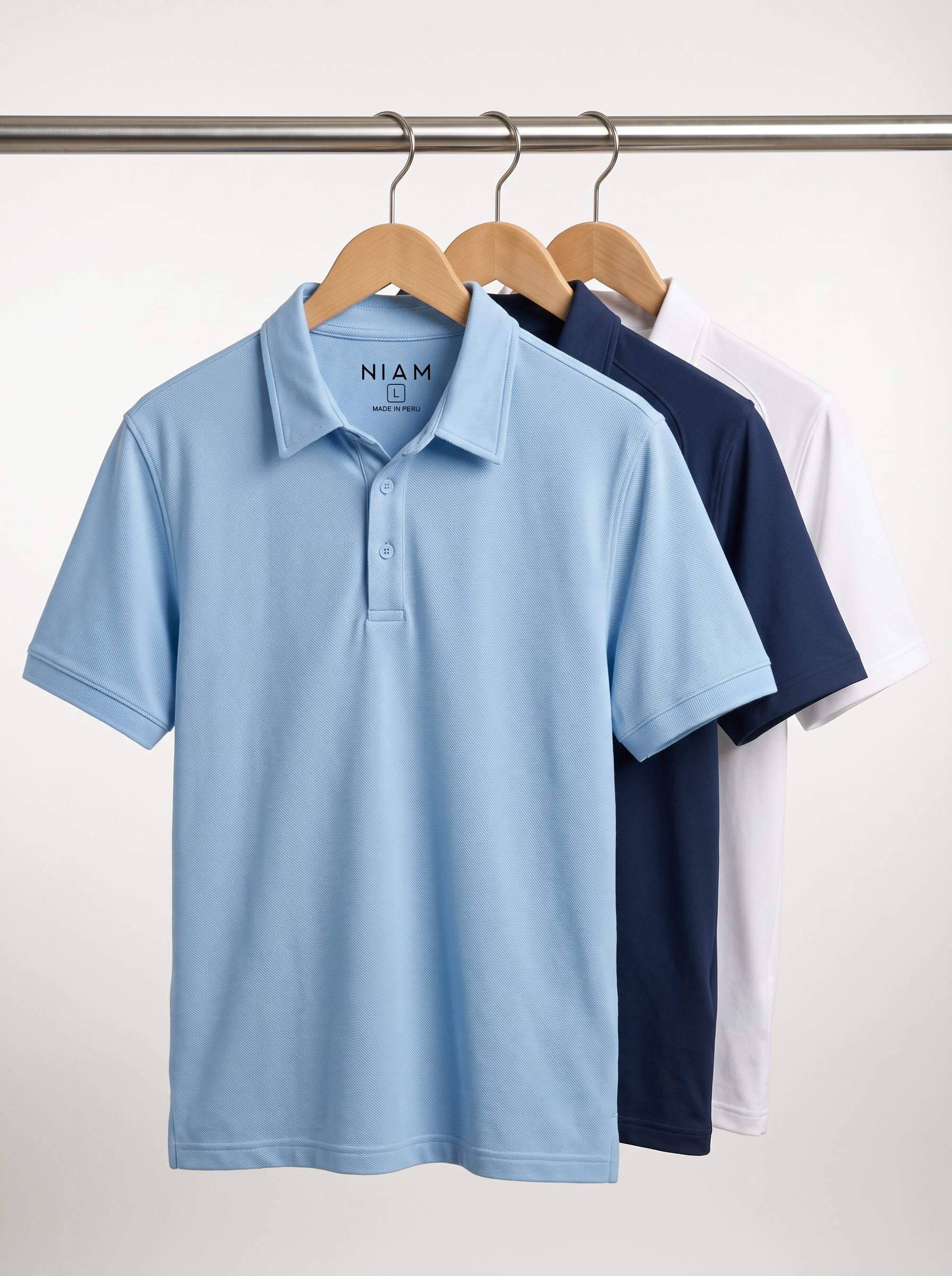 A pique polo and two performance polos on a studio rail