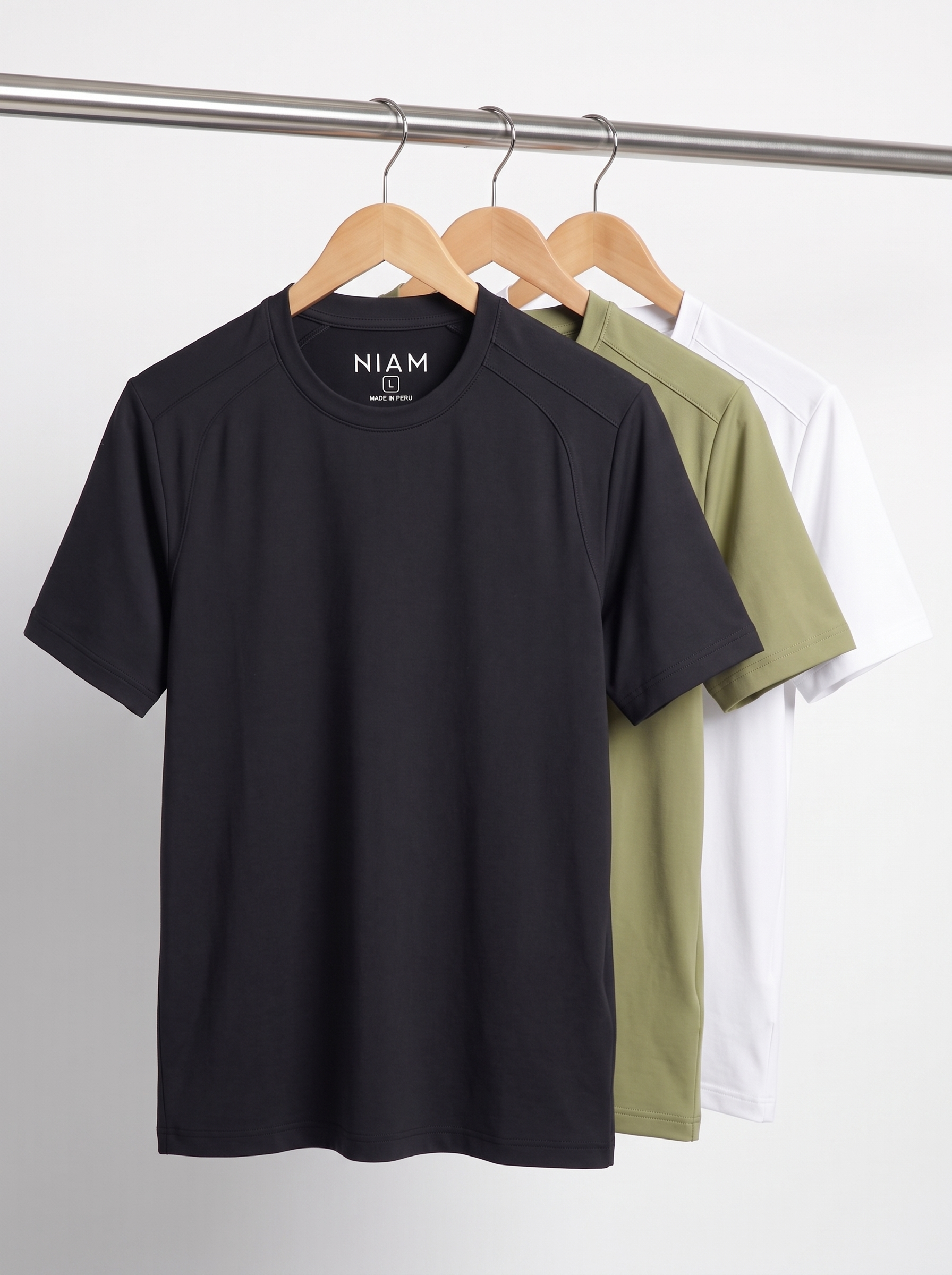 Three SwingFree performance crew tees on a studio rail